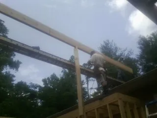 Carpenter setting a ridge beam over a new addition frame — Ice Dam Removal by Roofing Brothers in North Washington