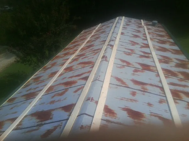Rusted metal roof panels with new wood purlins before replacement — Storm Damage Roof Repair in North Washington by Roofing Brothers